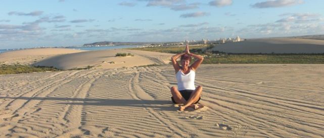 A woman doing yoga on the beach while on her travels A woman doing yoga on the beach while on her travels