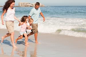 family running on a beach
