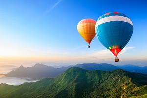 hot-air balloons flying over the mountain