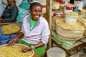 Happy woman selling cereals at town market