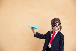 Portrait of young businessman with paper airplane. Success, creative and startup concept. Copy space for your text