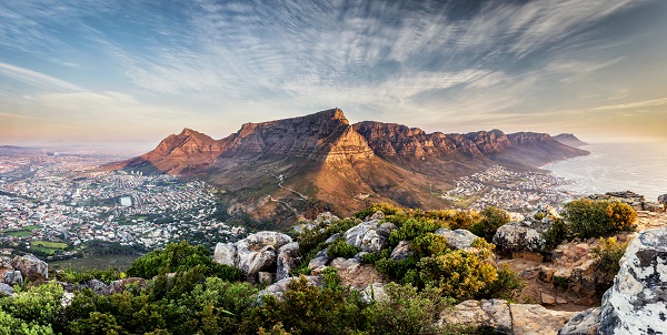 panoramic view of tall table mountains in the sunset, surrounded by white rocks and buildings