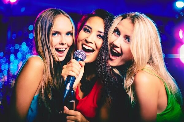 Three women singing Karaoke