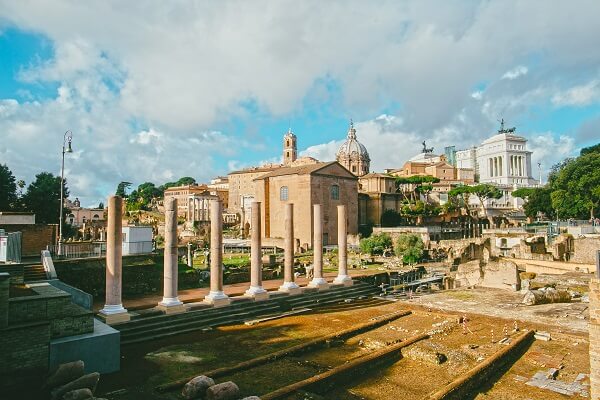 pillars and buildings in an ancient roman city with cloudy skies